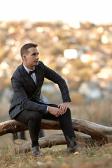 Fototapeta premium Handsome young man in classic checked suit outdoor