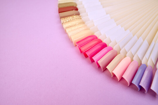 Multiсolor nail tips on a purple background. examples of manicure for nails. Palette with color samples of nail.