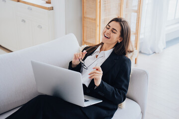 Joyful businesswoman laughing during a break from work at home