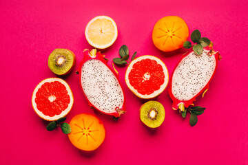 top view of citrus fruits on pink background
