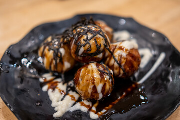 Takoyaki, an octopus balls, Japanese food served on plate with sauce