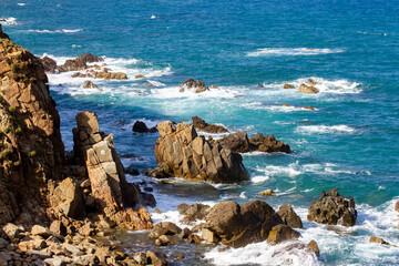 Waves Of Blue Sea Crashing On Rocks In Vietnam Coastal.