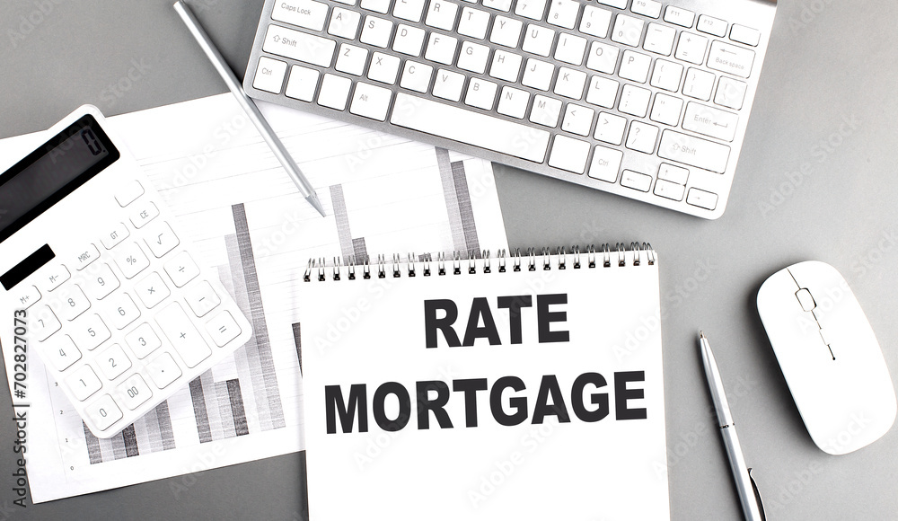 Poster rate mortgage text on notebook with calculator , chart and keyboard business concept