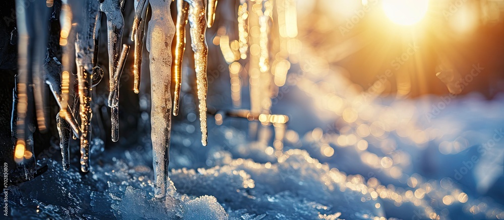 Poster melting icicles on the drainpipe against the bright sun. with copy space image. place for adding tex