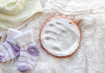 Handmade baby hand print inside clay for memory. White handprint on white dress and cute tiny socks...