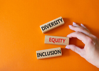 Diversity Equity Inclusion symbol. Concept words Diversity Equity Inclusion on wooden blocks. Beautiful orange background. Businessman hand. Business and Diversity Equity Inclusion concept. Copy space - obrazy, fototapety, plakaty