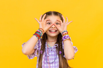 A beautiful little girl put on a lot of colorful beaded bracelets. Funny kid . Beading for children...