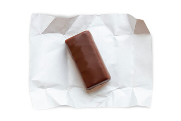 A chocolate bar lies on a white paper wrapper. Isolated on transparent background.