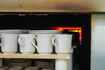 rows of white identical mugs visited in a muffle kiln at a porcelain factory in Likino-Dulevo in the Moscow region