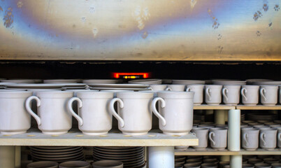 rows of white identical mugs visited in a muffle kiln at a porcelain factory in Likino-Dulevo in...