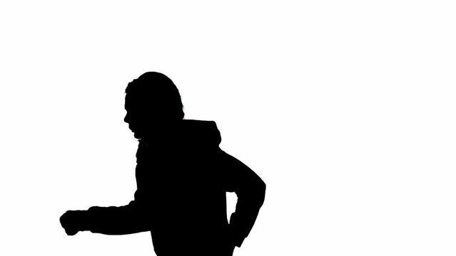 Black silhouette of a woman on a white isolated background. A young girl runs, fearfully looking around, fleeing faster from danger. Side view.