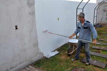 pintor trabalhando em pintura de muro 