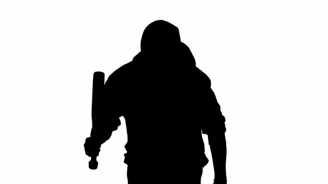 Black silhouette of thief on isolated white background. A male robber in hoodie and balaclava walks with a wooden club in his hands, preparing to commit a crime.