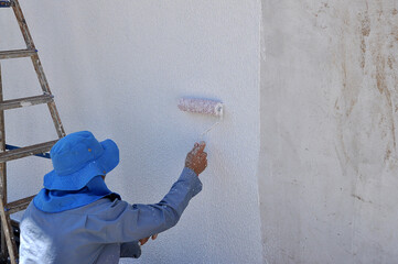 pintor trabalhando em pintura de casa 