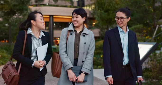 Walking, conversation and business people in the city talking for communication or bonding. Smile, discussion and professional Asian colleagues speaking and laughing together commuting in town.