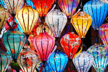 Night view of Colourful cloth lanterns lamp light shades hanging outside in Hoi An, Vietnam -...