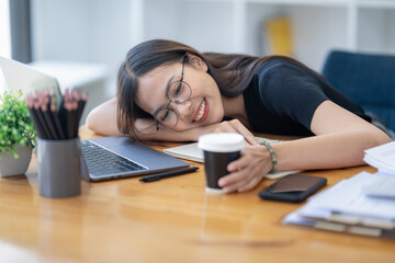 Freelance Asian businessperson, businesswoman sitting collapsed on  her arms in a good mood, taking...