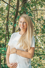 blonde pregnant happy mother outdoor