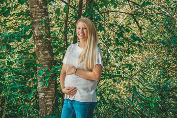 blonde pregnant happy mother outdoor