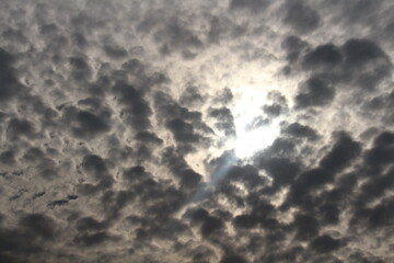 Rays of sun peeking out from behind some dark clouds in the sky