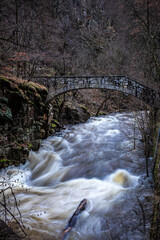Eine reißender Fluss, die Bode, mit einer Brücke, dem Jungfernstieg, aus Stein im Harz bei Tahle