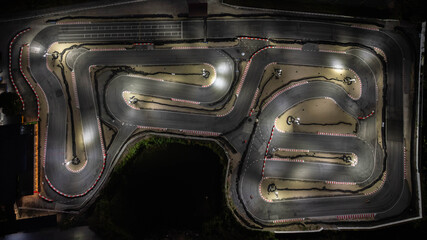 Aerial top view race kart track at night, Track for auto racing top view, Car race asphalt and curve street circuit, Aerial view asphalt race track at night.