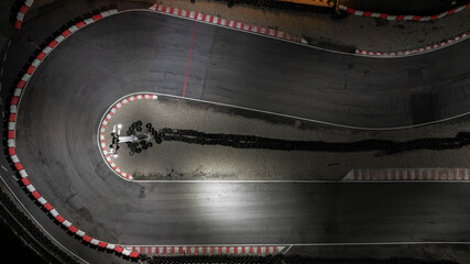 Aerial top view race kart track at night, Track for auto racing top view, Car race asphalt and curve street circuit, Aerial view asphalt race track at night.