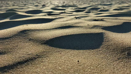 Pequeñas dunas de arena en la playa en un atardecer