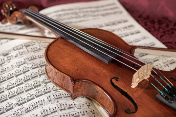 Fototapeta na wymiar Beautiful violin and note sheets on purple background