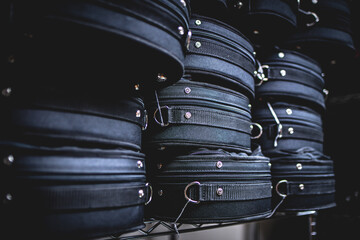 Many black violin cases stacked on top of each other closeup