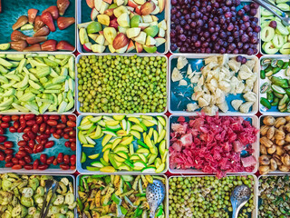 Top view of assorted fruits and pickled fruits on trays for sale in street market, healthy food concept Include high vitamin fruits, fresh fruits, Thai fruits, Street food.Variety fruits as background