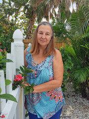 senior adult woman portrait beside fence and flowers