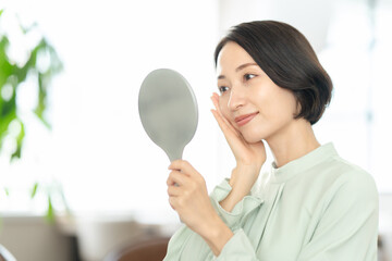 手鏡で肌を確認する女性　ヘアケア　スキンケア