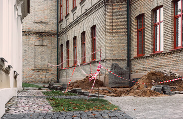 Striped red and white tape blocks way to damaged old building needs renovation and repair at town...