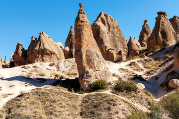 Sunny Cappadocia Rock Formations Landscape. Scenic view of Cappadocia's fairy chimneys, suitable for travel and tourism themes.