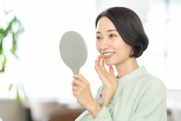 白い歯の女性　手鏡　ビューティー