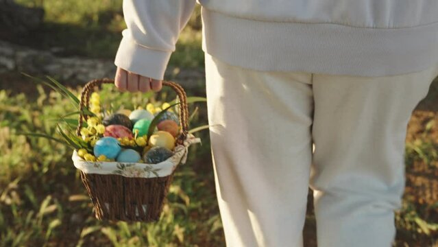 A walk behind a woman in white carrying a basket of painted Easter eggs. Sunny forest at dawn.