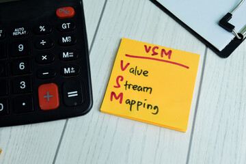 Concept of VSM - Value Stream Mapping write on sticky notes isolated on Wooden Table.