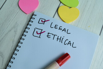 Concept of Legal and ethical write on book isolated on Wooden Table.
