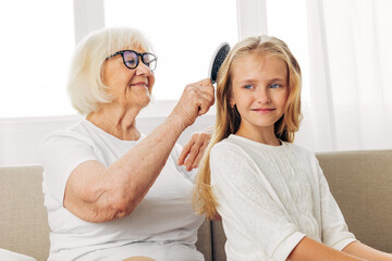 Woman girl comb grandmother love sofa couch family child granddaughter home happy