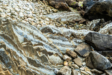 Rocky ocean shore. Pebbles and boulders on seashore