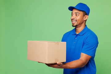Side view professional fun delivery guy employee man wear blue cap t-shirt uniform workwear work as...