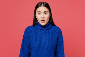 Young shocked frightened sad woman of Asian ethnicity she wears blue sweater casual clothes look camera with opened mouth isolated on plain pastel pink background studio portrait. Lifestyle concept.