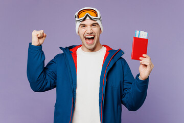 Traveler winner skier man in blue windbreaker jacket ski goggles mask hold passport ticket isolated...
