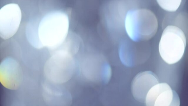 Abstract blurred bokeh glowing background. Crystal Holiday bokeh backdrop. Blinking shining reflection. Diamond light refraction and rays. Decoration. Wallpaper. Slow motion