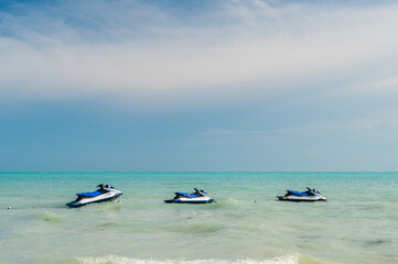 Three Jet Ski's, floating on a tropical sea. 