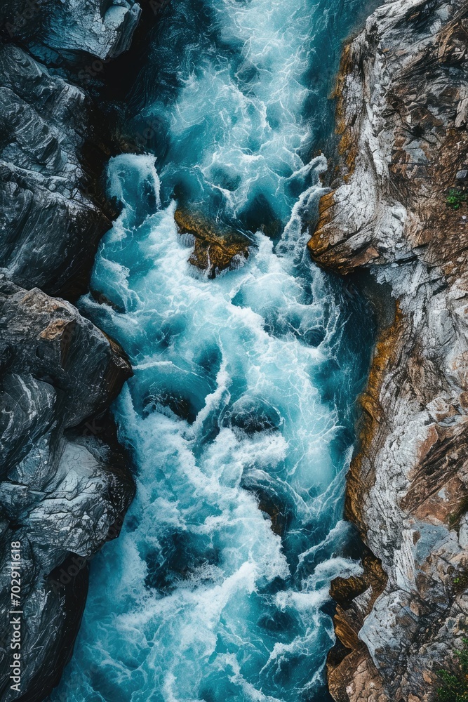 Poster an aerial view of a river flowing between two large rocks in the middle of a river surrounded by gre