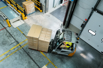 Un chariot élévateur avec des cartons dans un entrepôt de stockage
