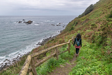 Woman walking along the Asturian Coast. Muros de Nalón