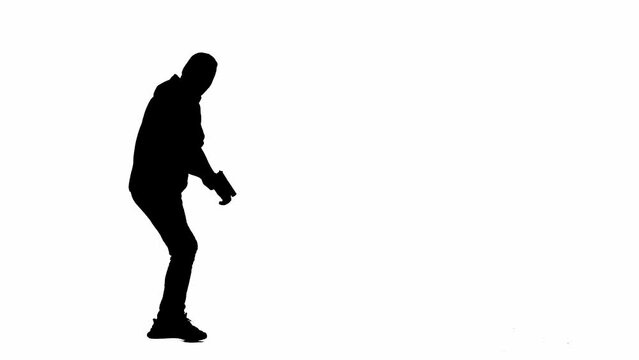 Black silhouette of thief on isolated white background. Male robber in hoodie and balaclava walking with a gun in his hands, preparing to commit a crime. Side view.